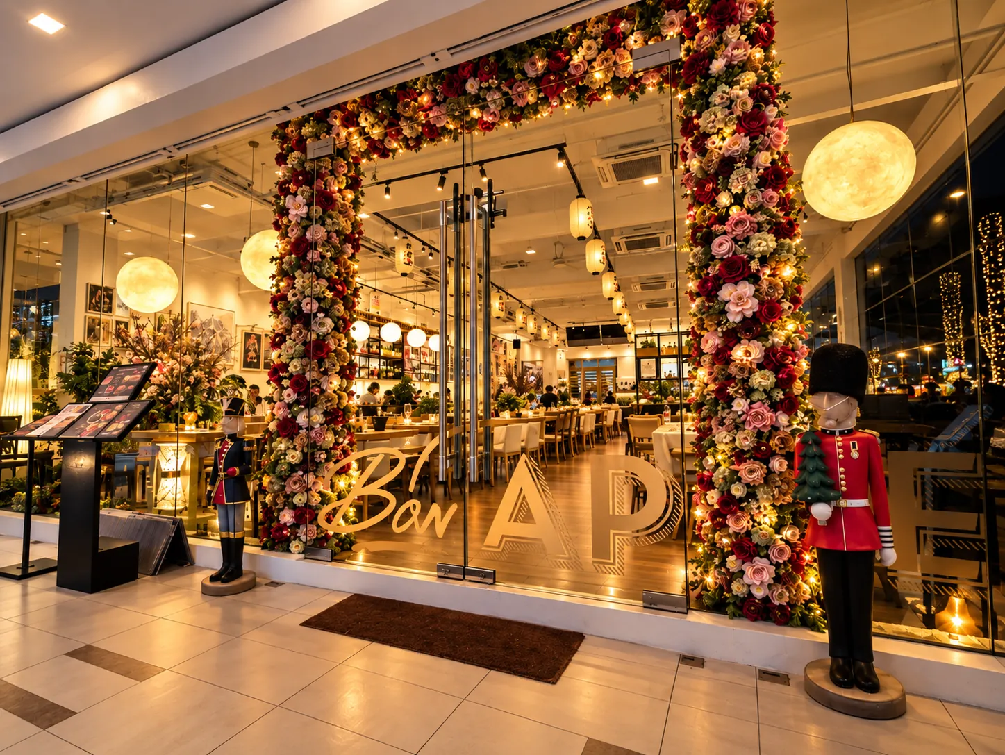 The flower arch at the entrance, with Bon Appétit in gold on the glass